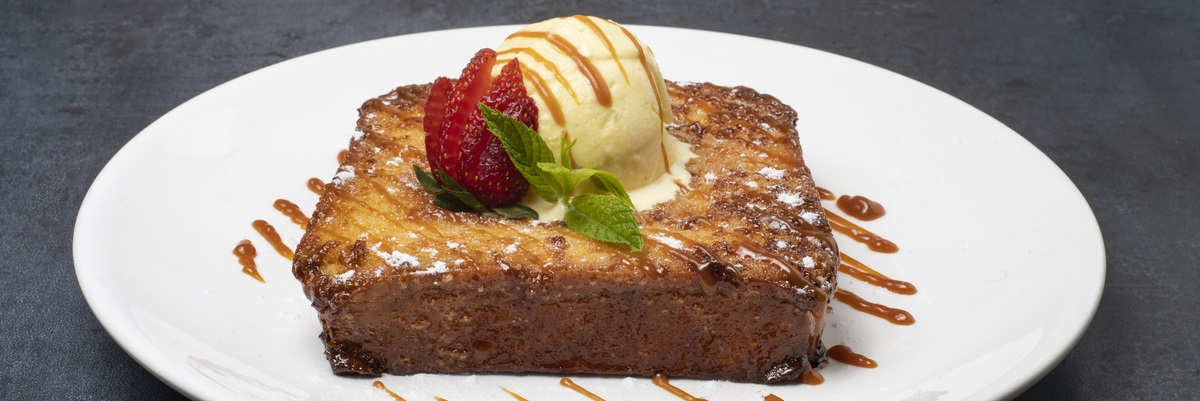 Presentación sugerida de la torrija brioche con crema de almendras caramelizada. En este ejemplo se acompaña de helado y fruta.