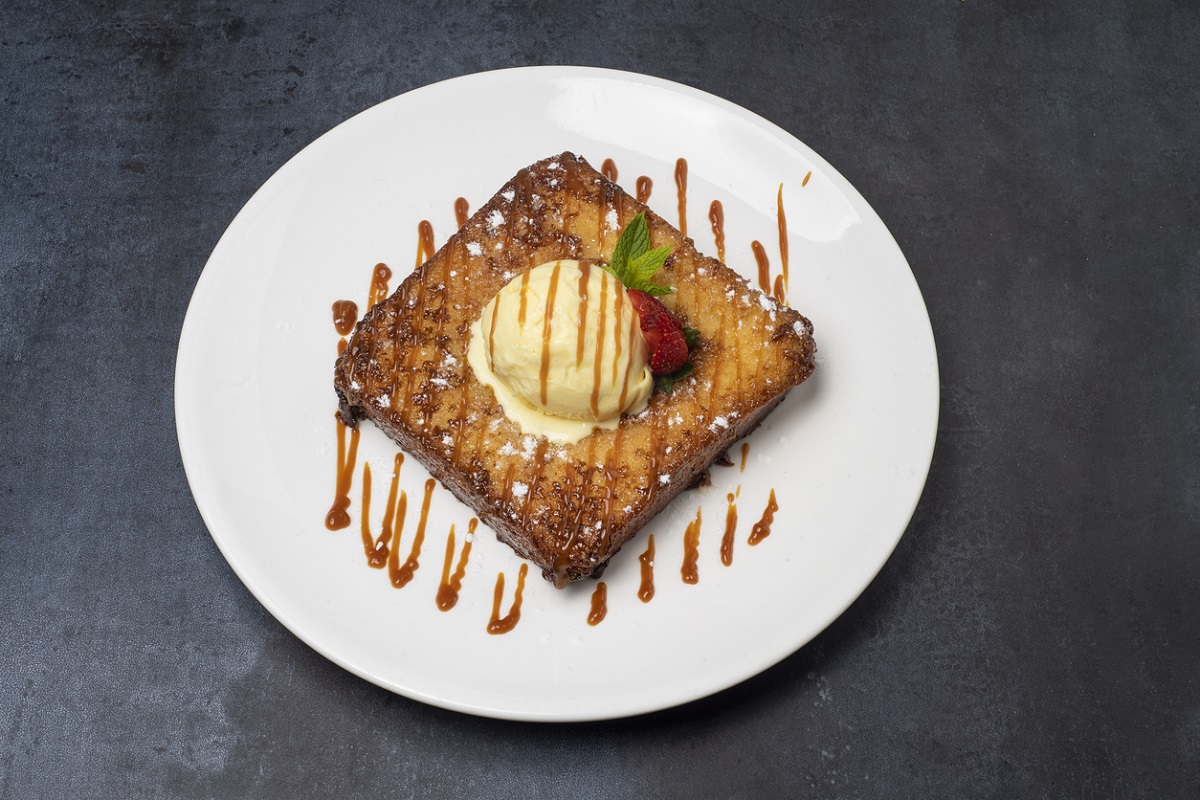 Presentación sugerida de la torrija brioche con crema de almendras caramelizada. En este ejemplo se acompaña de helado y fruta.